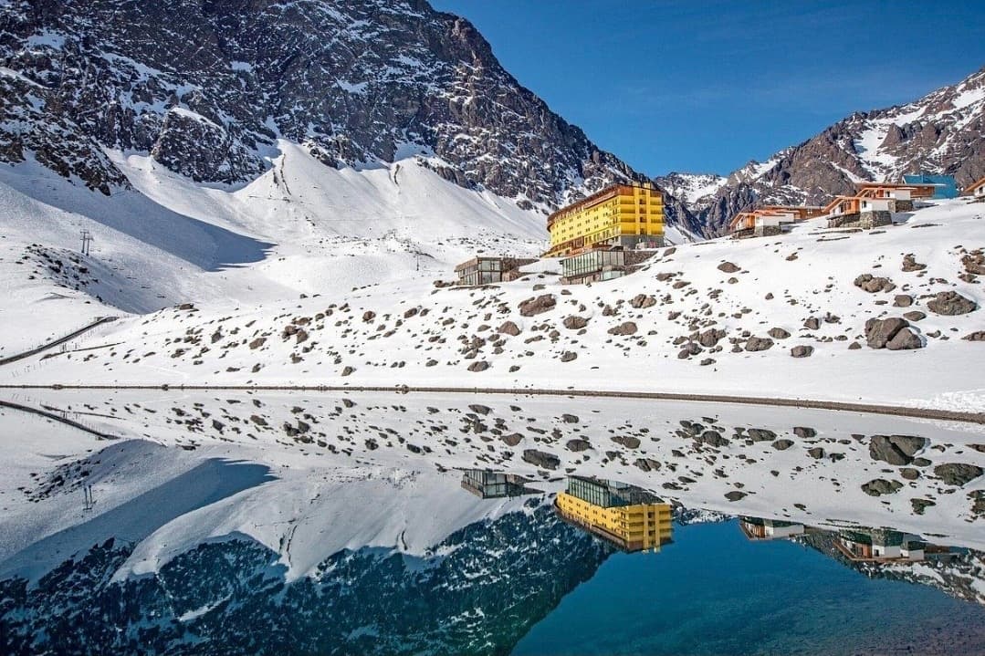 Hotel Portillo y cumbres nevadas reflejados en la Laguna del Inca